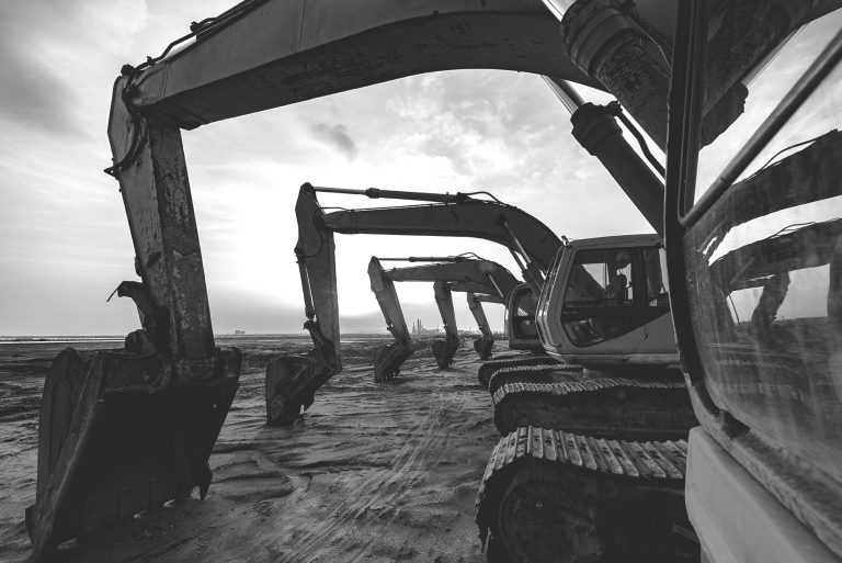 multiple excavators parked in a row